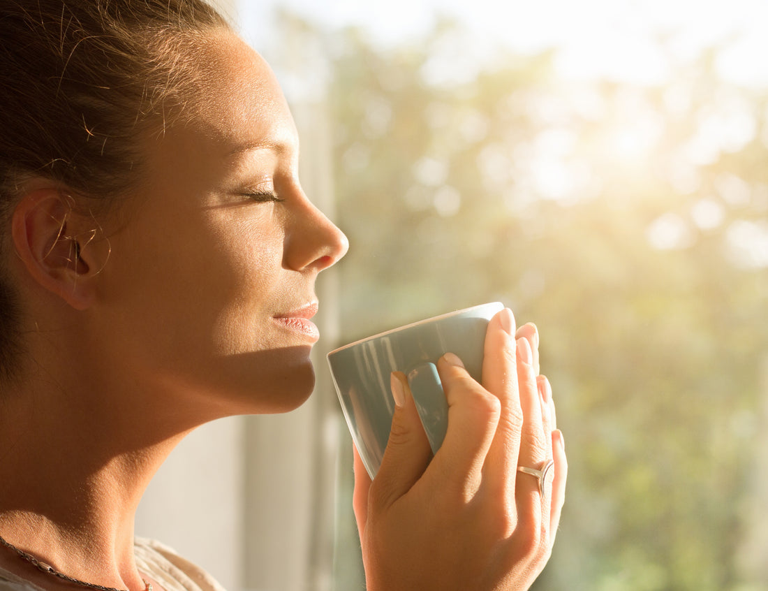 Woman drinking a hot cup of tea made with the BIBO Water Bar